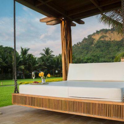 Brown Wooden Framed With White Mattress Hanging Bed Surrounded by Green Grass